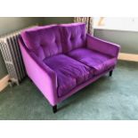 A smart contemporary two seater settee upholstered on bright mauve moquette,