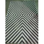 A black and white handmade contemporary rug; 231cm x 161cm.