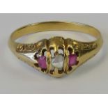 An Edwardian ruby and diamond ring, central diamond flaked by rubies, unmarked yellow metal setting,