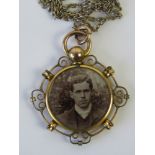 An Edwardian rolled gold memorial pendant having glass panel to each side containing vintage