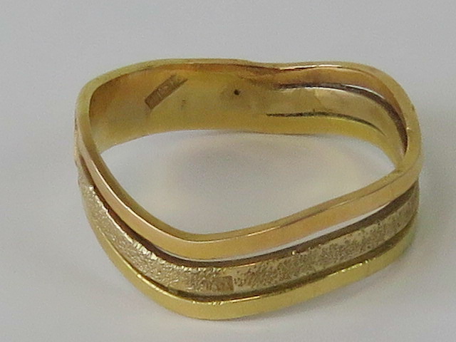 A yellow metal three row wave ring having triple Arabic hallmark, size V, 5.1g.