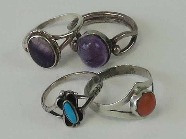 Three silver rings; a sterling silver and turquoise ring size I and two rings set with amethyst,