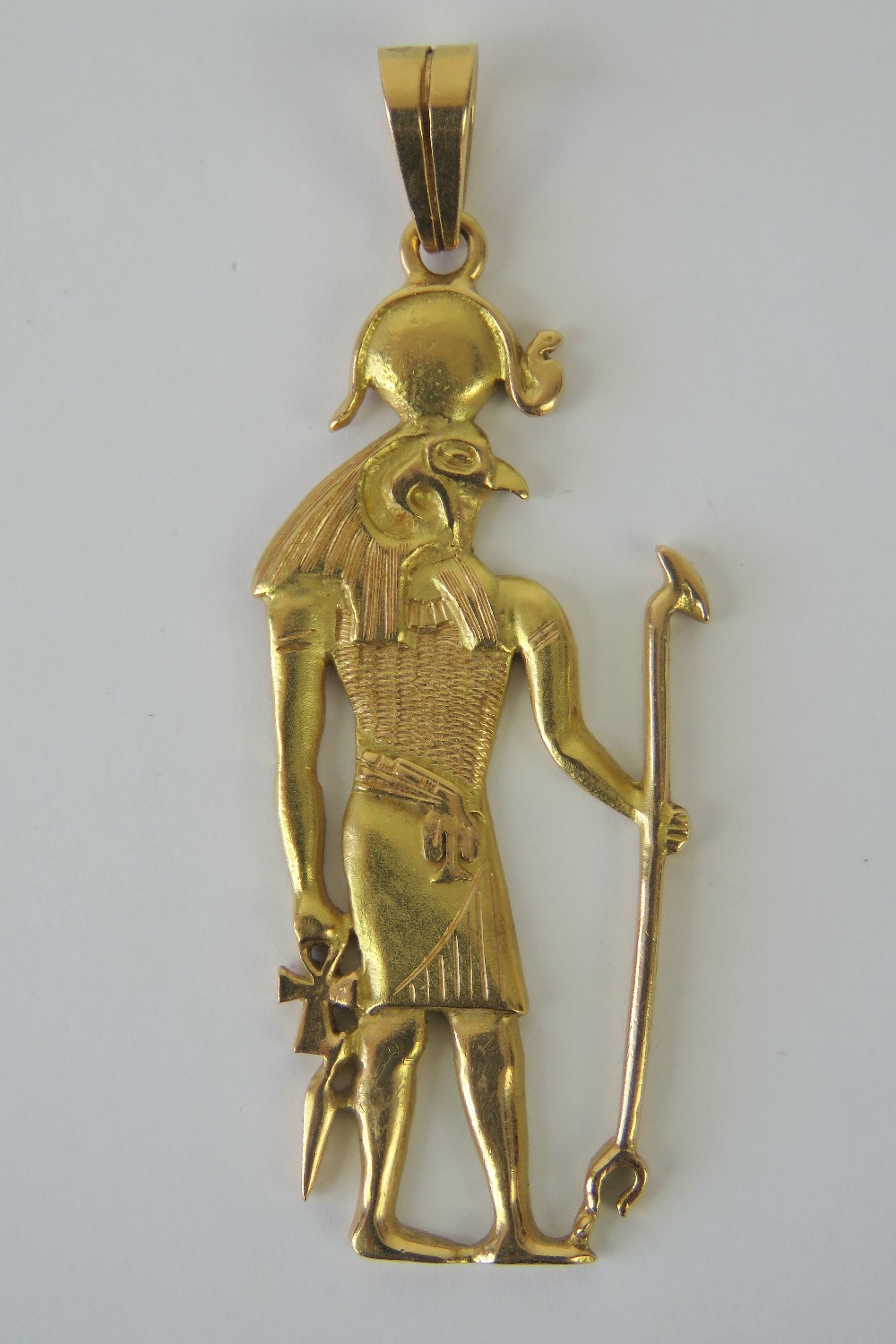 A yellow metal pendant depicting the Egyptian god Horus, having single and double Arabic hallmark,