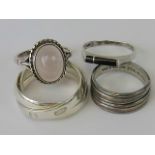 Four silver rings; a triple band ring size L-M, a rose quartz ring size L,