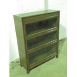 A three sectional library bookcase in the style of Globe Wernicke having up and over glazed doors,