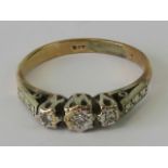 A 9ct gold and diamond ring having three illusion set diamonds in white metal,