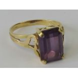 An emerald cut alexandrite ring, approx 5ct, in claw set ring having foliate pattern to shoulders,