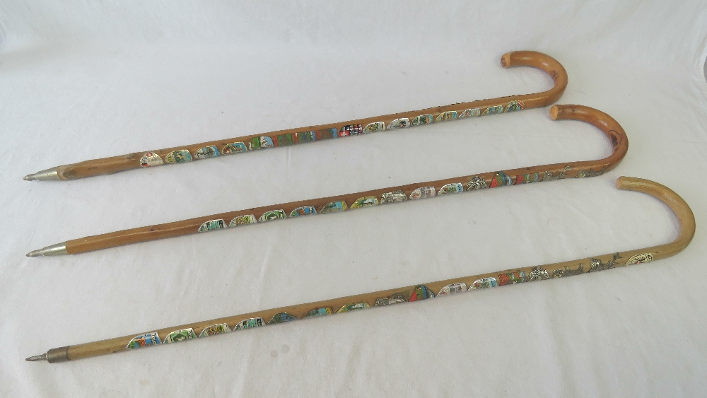 Three walking sticks each emblazoned wit