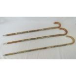 Three walking sticks each emblazoned wit