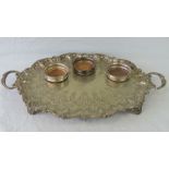 A large and impressive shaped and engraved twin handled serving tray having four scrolled feet