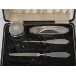 A HM silver part necessaire comprising nail file, cuticle knife, buffer and rouge pot.