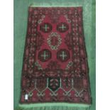 A prayer rug in red ground with black pattern, approx 125 x 67cm.