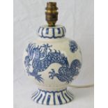 A Charlotte Rhead Bursley Ware lamp having off white ground with blue dragon and clouds upon,