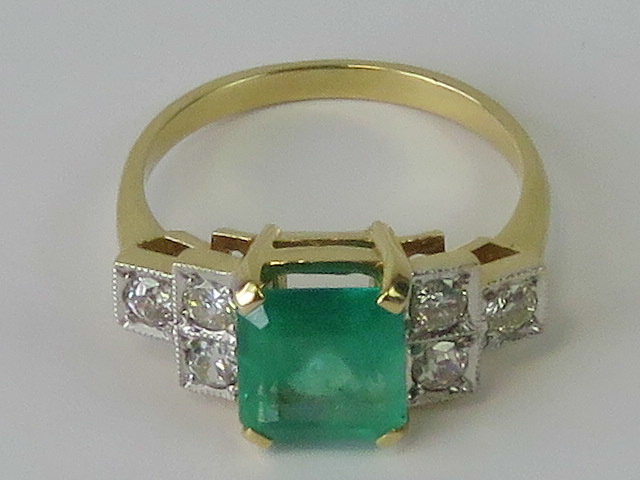 An Art Deco style emerald and diamond ring, large central emerald cut emerald approx 1.