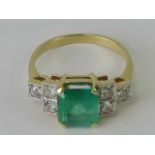 An Art Deco style emerald and diamond ring, large central emerald cut emerald approx 1.