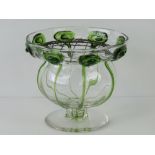 An Art Nouveau glass vase of urn shaped design with everted border having green glass trailing