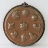 A copper mold having various shapes upon and hanging loop, 29cm dia.