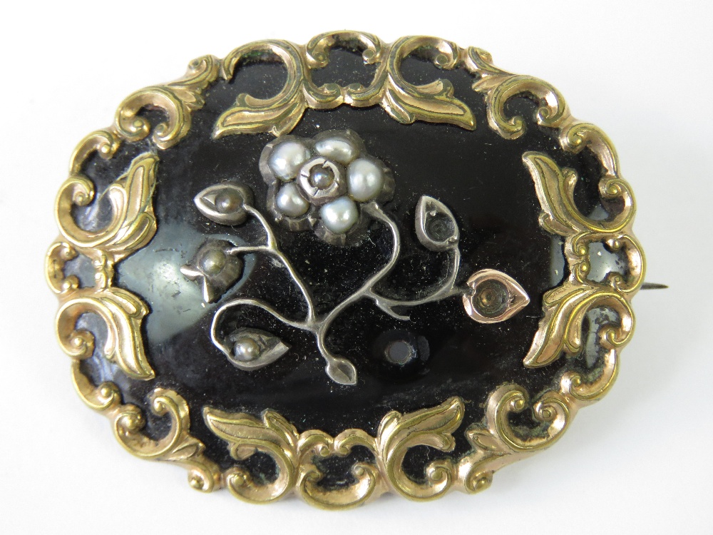 A Victorian mourning brooch having black enamel ground,