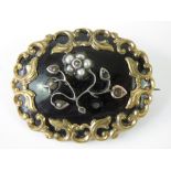 A Victorian mourning brooch having black enamel ground,