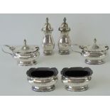 A HM silver cruet set comprising two mustard pots and two salts having Bristol blue glass liners