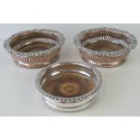 A pair of silver plated wine coasters each having wooden base with white metal Lion crest to centre,