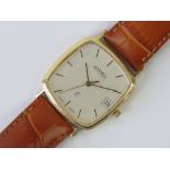 A 9ct gold Roamer wristwatch having white square shaped dial with yellow metal hands and batons,