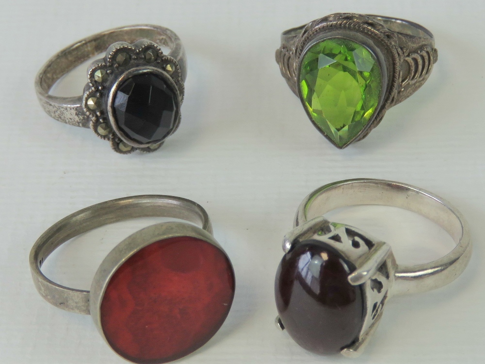 Four silver rings each with single stone and stamped 925; peridot size Q,