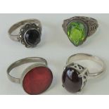 Four silver rings each with single stone and stamped 925; peridot size Q,