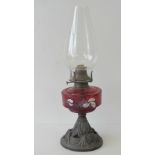 An Edwardian oil lamp with cast bass and glass reservoir, marked Queen Anne upon,
