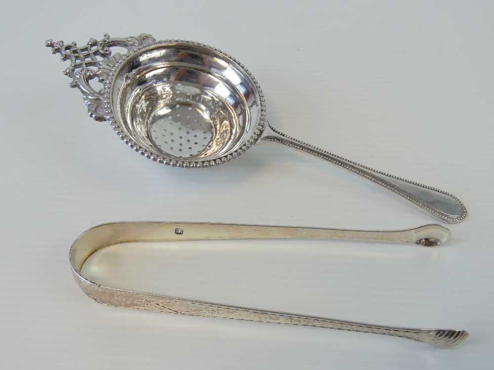 A pair of silver sugar tongs bearing partial hallmark (lion passant with makers mark for John James