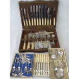 An oak canteen of cutlery together with boxed sets of cake forks, butter knives and dessert spoons.