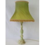 An alabaster lamp base, wired for electricity and complete with lime green lamp shade,