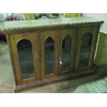 A carved oak sideboard having central twin doors flanked by single door to each side,