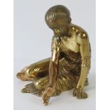 An early 20th century brass figure of a seated girl in Classical Roman dress with braided hair,