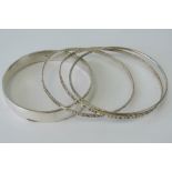 A set of two Sterling silver bangles, together with an unmarked white metal bangle,
