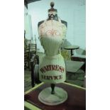 A restaurant half mannequin raised over circular wooden base, painted apron 'Waitress Service',