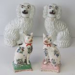 A pair of 19th century seated floral Staffordshire cats each raised over a 'cushion' base,