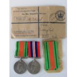 A British WWII War and Defence medal pair complete with ribbons and bar,