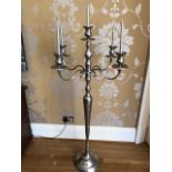 A contemporary polished steel five sconce pricket type freestanding candlestick of ecclesiastical