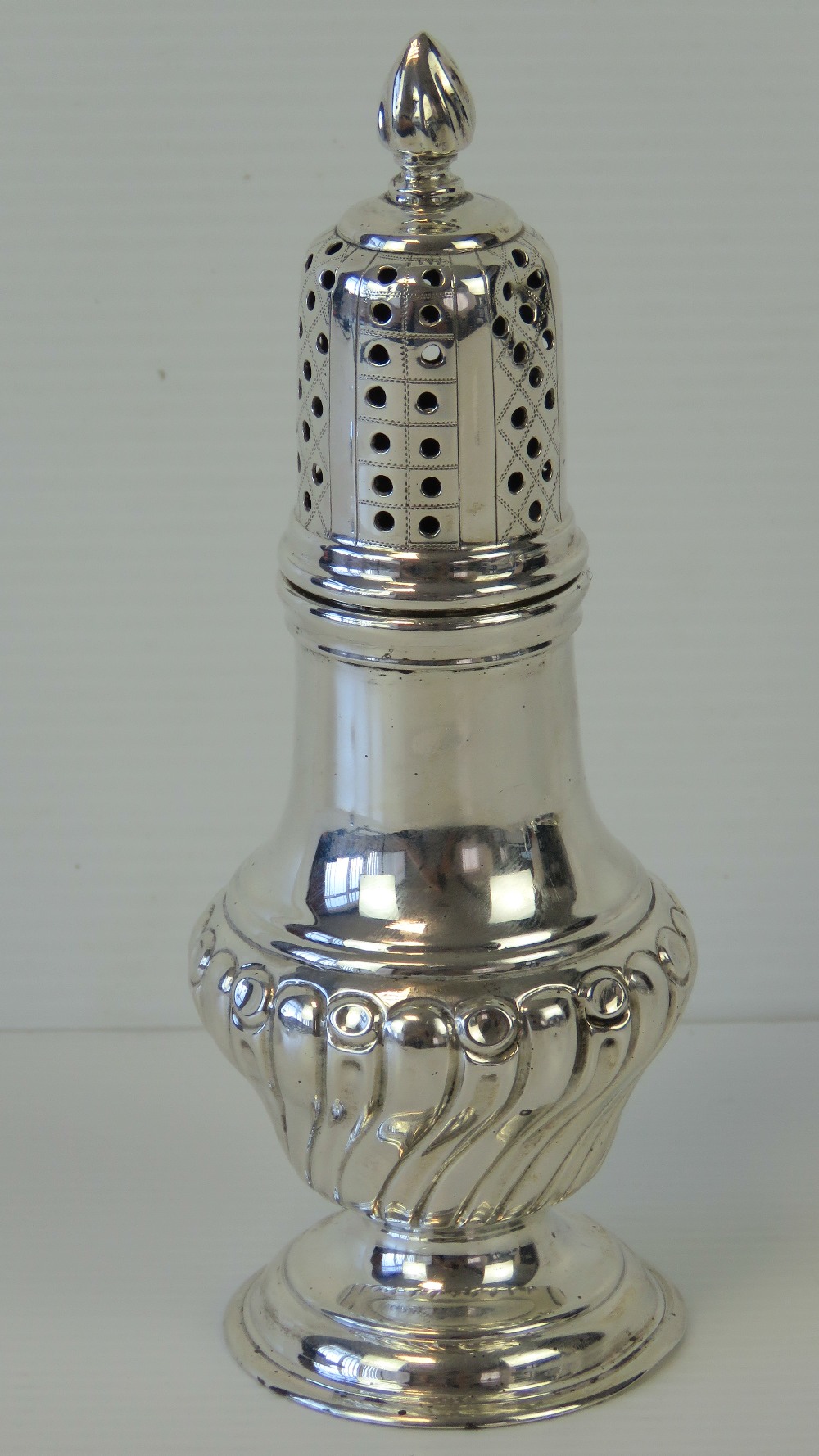 A HM silver sugar caster having gadrooned body over single foot,