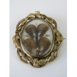A Victorian memorial brooch/pendant having scrolling ivy leaf pinchbeck frame,