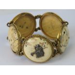 An early 20th century Japanese ivory bracelet of five circular panels in gilt metal roundel links,