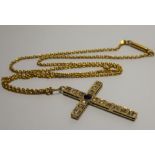 A yellow metal crucifix set with diamonds and a central sapphire (tests as 18ct gold).