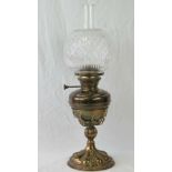 A brass oil lamp having chimney and cut glass shade, standing 59cm high.