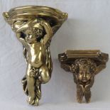 Two gilded wall plinths having cherubs upon.