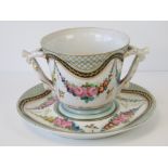 A large hand painted and gilded porcelain cup and saucer marked for Limoges. Saucer 8" Diameter.