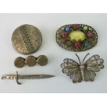 Five brooches; a white metal disc having engraved ivy pattern upon,