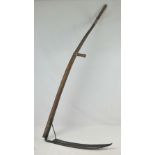 An old scythe with ash shaft and handles.