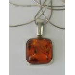 A silver and Baltic amber pendant complete with snake link chain, amber cabachon approx 1.