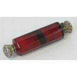 A ruby glass double ended scent bottle having repoussé white metal lids, having stopper, a/f, 10.